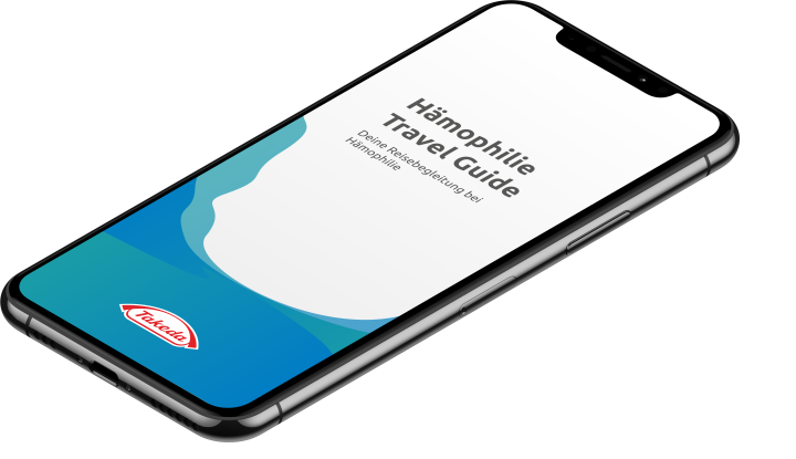 Auf dem Bild ist ein Smartphone zu sehen, auf dessen Display die Startseite einer App mit dem Titel „Hämophilie Travel Guide“ angezeigt wird. Rechts daneben steht ein erläuternder Text, der beschreibt, dass der „Hämophilie Travel Guide“ ein persönlicher Reisebegleiter für Menschen mit Hämophilie und anderen Blutgerinnungsstörungen ist. Darunter befindet sich ein roter Button mit der Aufschrift „Zum Travel Guide App“. Das Bild suggeriert, dass die App Betroffene bei der Reiseplanung unterstützt und ihnen unt