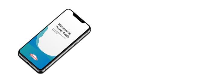 Links im Bild ist ein Smartphone zu sehen, auf dessen Display „Hämophilie Travel Guide“ steht. Rechts daneben befindet sich ein Textfeld mit einer kurzen Beschreibung der App: Es handelt sich um einen persönlichen Reisebegleiter für Menschen mit Hämophilie und anderen Blutgerinnungsstörungen. Darunter gibt es einen roten Button mit der Aufschrift „Zum Travel Guide App“.